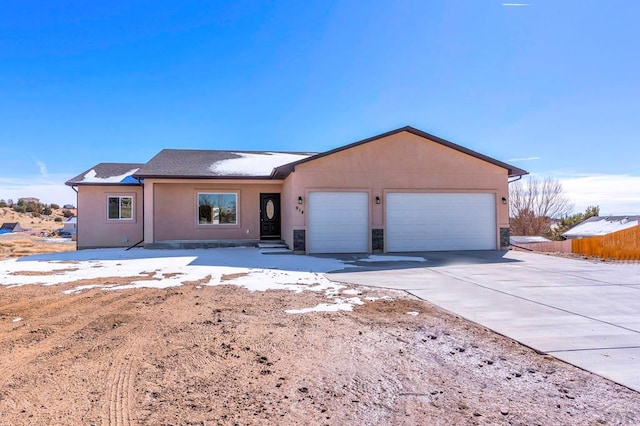 ranch-style home featuring stucco siding, fence, a garage, stone siding, and driveway