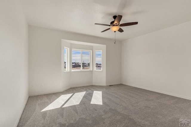 unfurnished room with light carpet, ceiling fan, and baseboards