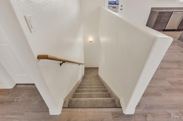 stairs featuring wood finished floors