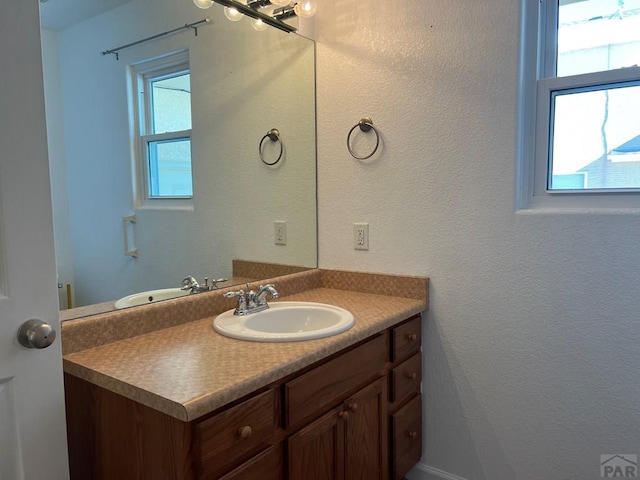 bathroom featuring a textured wall and vanity