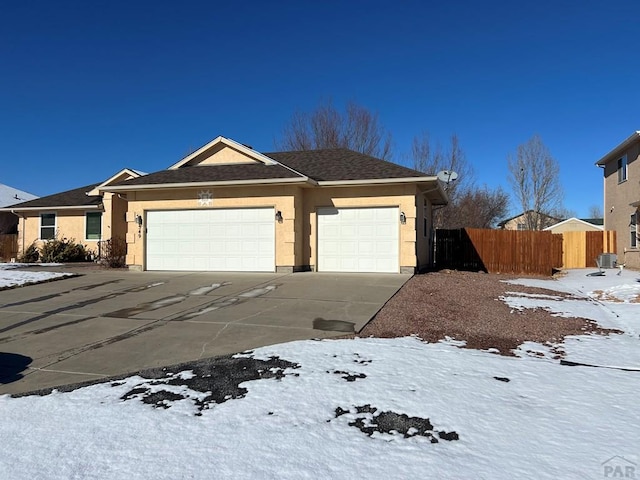 ranch-style house featuring fence, driveway, an attached garage, and stucco siding