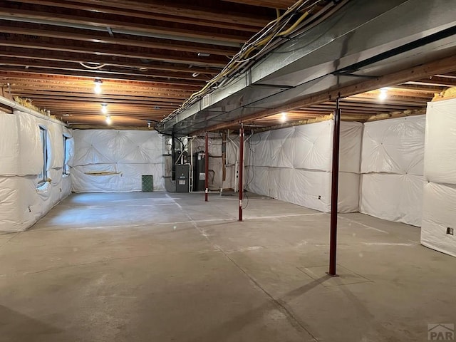 unfinished basement featuring water heater and heating unit