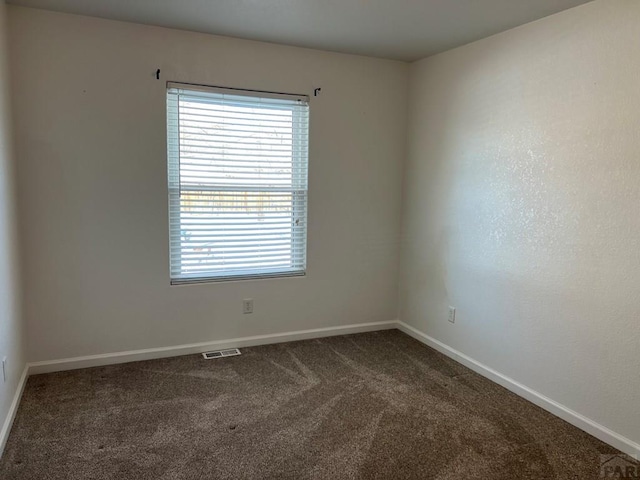 carpeted empty room with visible vents and baseboards