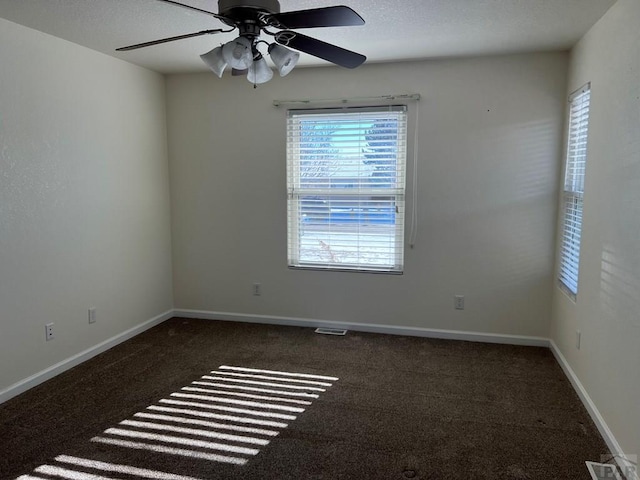 unfurnished room featuring ceiling fan, baseboards, and dark carpet