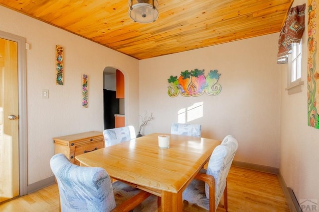 dining area with wooden ceiling, light wood-style flooring, arched walkways, and baseboards