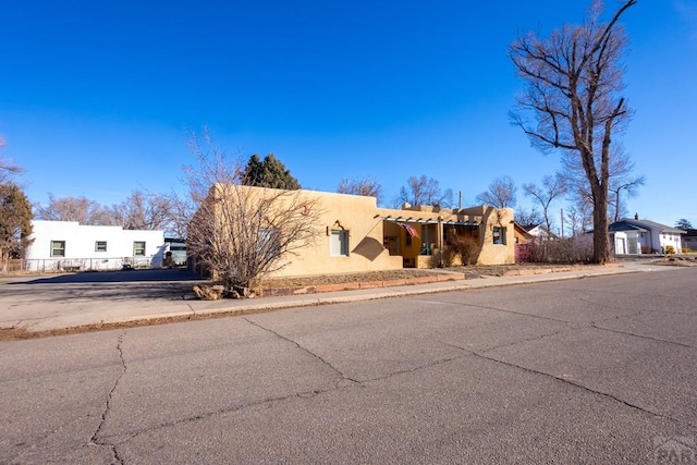 pueblo-style home with a residential view and stucco siding