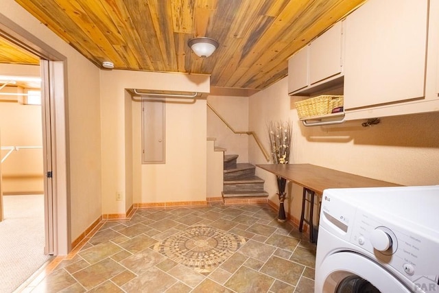 clothes washing area with stone finish floor, wooden ceiling, cabinet space, and washer / dryer