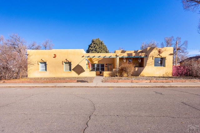 pueblo-style house featuring stucco siding