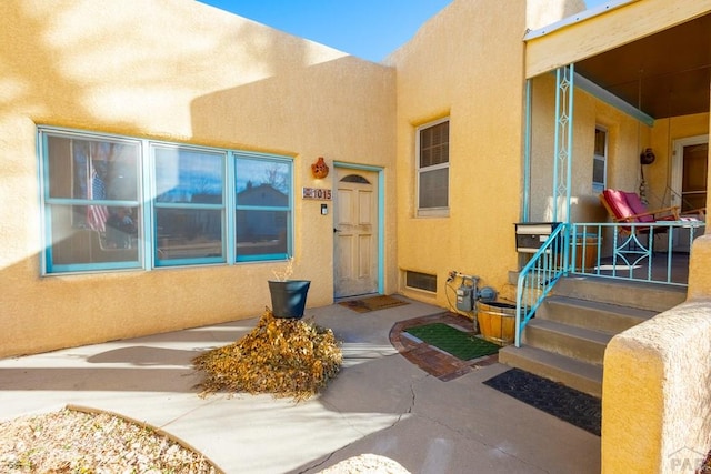 doorway to property with visible vents and stucco siding