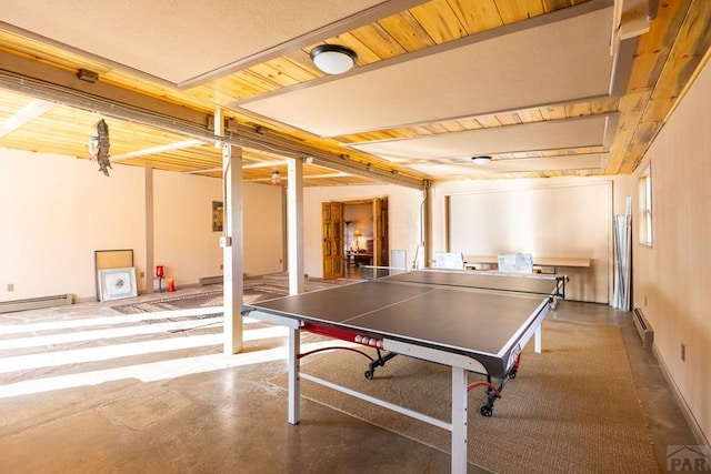 recreation room featuring finished concrete floors and baseboard heating