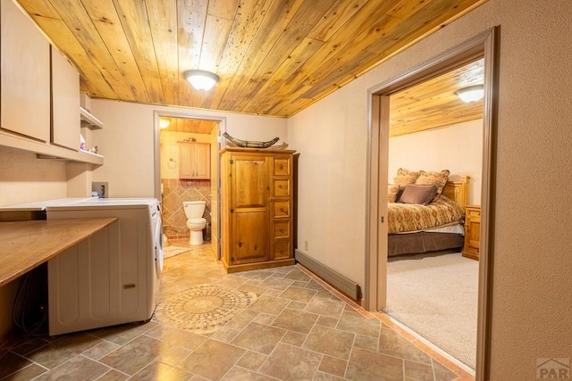 clothes washing area with stone finish flooring, washer hookup, wooden ceiling, and cabinet space