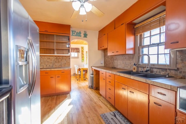 kitchen with tile countertops, a sink, light wood-style floors, stainless steel fridge with ice dispenser, and open shelves