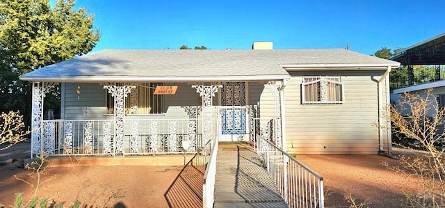 view of front of home featuring a shingled roof and a porch