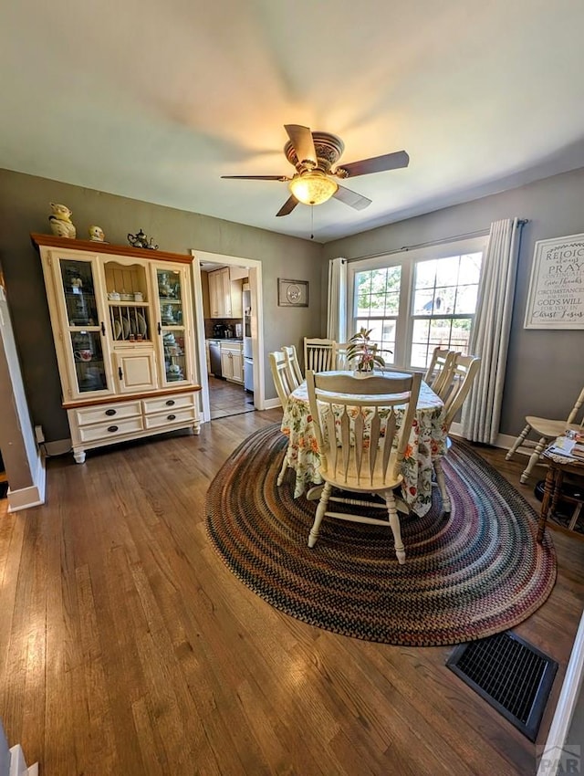 dining room with dark wood-style floors, baseboards, and a ceiling fan