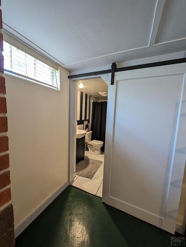 full bath featuring finished concrete floors, toilet, vanity, and baseboards