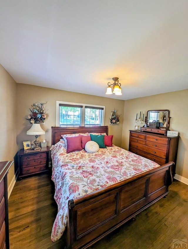 bedroom with dark wood-style floors and baseboards