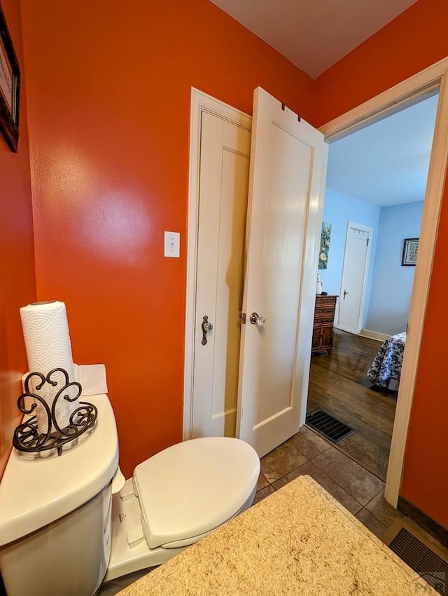 bathroom featuring toilet, baseboards, visible vents, and tile patterned floors