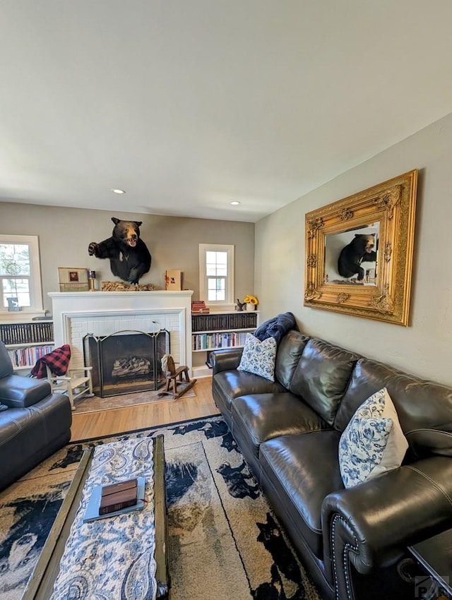 living room with a fireplace, wood finished floors, and recessed lighting