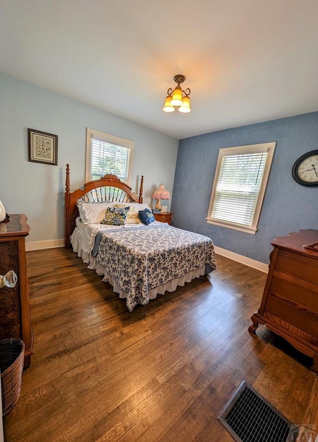 bedroom featuring dark wood-type flooring, visible vents, and baseboards