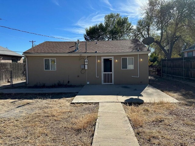 back of property with stucco siding, fence, and a patio