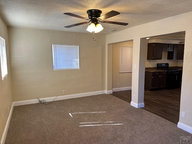 spare room featuring visible vents, dark carpet, ceiling fan, a textured ceiling, and baseboards