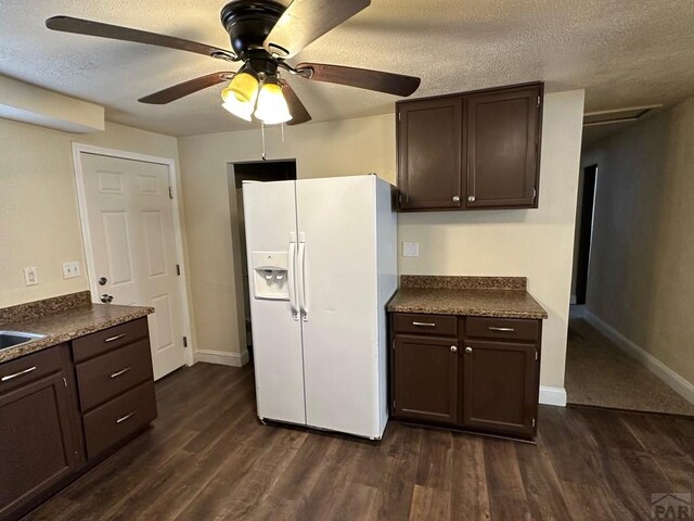 kitchen featuring dark countertops, dark wood-style floors, white refrigerator with ice dispenser, and dark brown cabinets