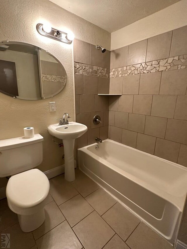 bathroom with a textured wall, toilet,  shower combination, tile patterned flooring, and a textured ceiling