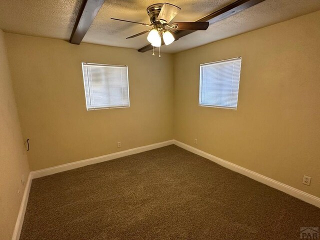 unfurnished room featuring a textured ceiling, dark colored carpet, a ceiling fan, and baseboards