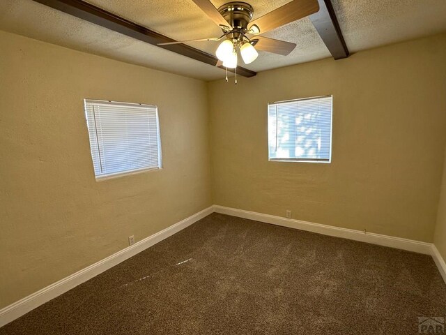 unfurnished room featuring dark carpet, a textured ceiling, baseboards, and ceiling fan