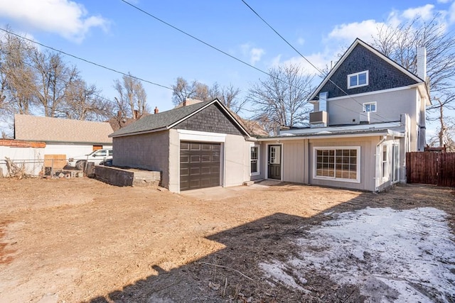back of house with fence and dirt driveway