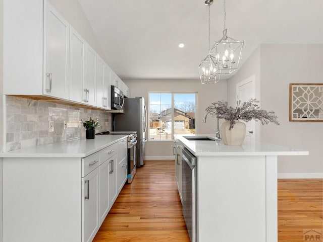 kitchen featuring stainless steel appliances, white cabinetry, and light countertops