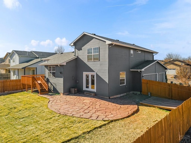 rear view of house with a yard, a patio, french doors, and a residential view