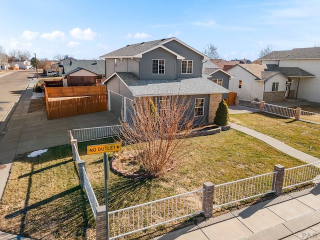 view of front of house with a garage, a fenced front yard, and a residential view