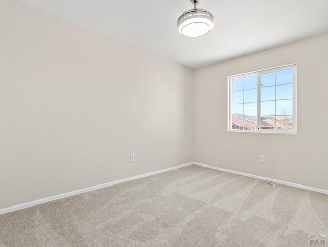 unfurnished room with light carpet and baseboards