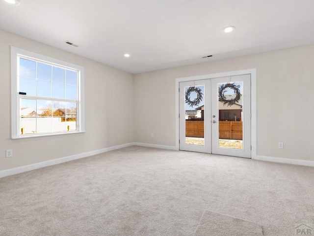 spare room featuring recessed lighting, light carpet, visible vents, baseboards, and french doors