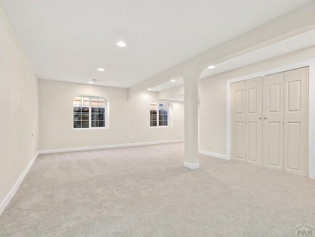 below grade area featuring recessed lighting, light carpet, and baseboards