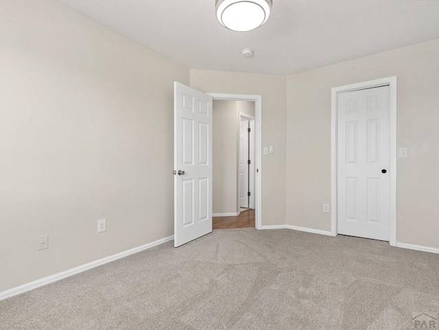 unfurnished bedroom with light carpet and baseboards