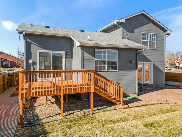 back of house with a wooden deck, fence, a lawn, and a patio