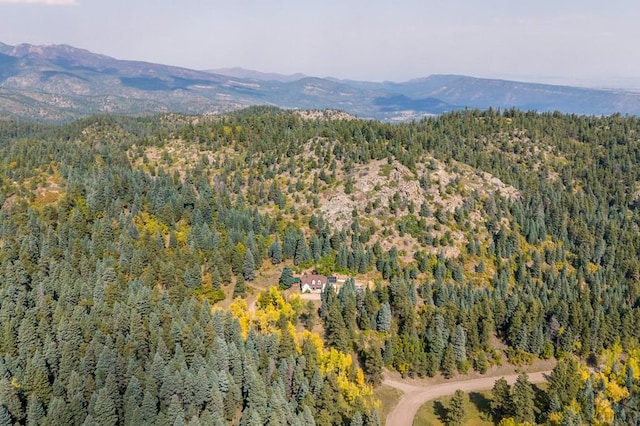 drone / aerial view with a wooded view and a mountain view