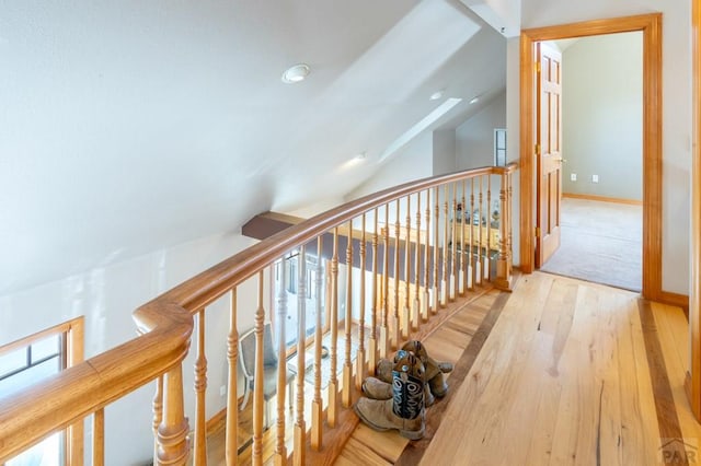 hall with lofted ceiling, light wood-style flooring, and baseboards