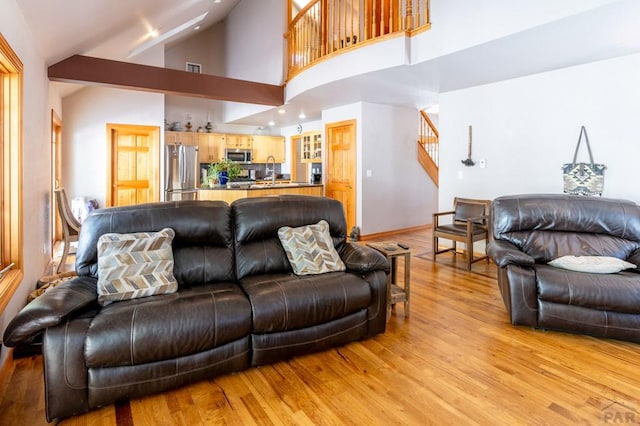 living room featuring light wood finished floors, recessed lighting, stairway, vaulted ceiling, and baseboards