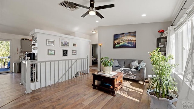 living room featuring visible vents, ceiling fan, wood finished floors, and lofted ceiling