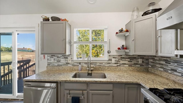 kitchen with stainless steel dishwasher, stove, wall chimney range hood, a sink, and decorative backsplash