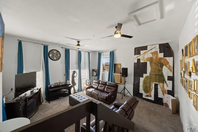 carpeted living room with attic access and ceiling fan