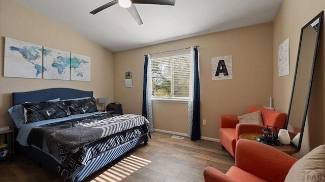 bedroom with a ceiling fan, visible vents, wood finished floors, lofted ceiling, and baseboards