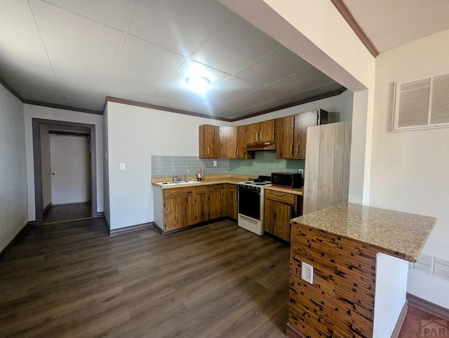 428 Elm Ave, Las Animas, CO 81054 - kitchen featuring white range, light countertops, black microwave, under cabinet range hood, and brown cabinetry