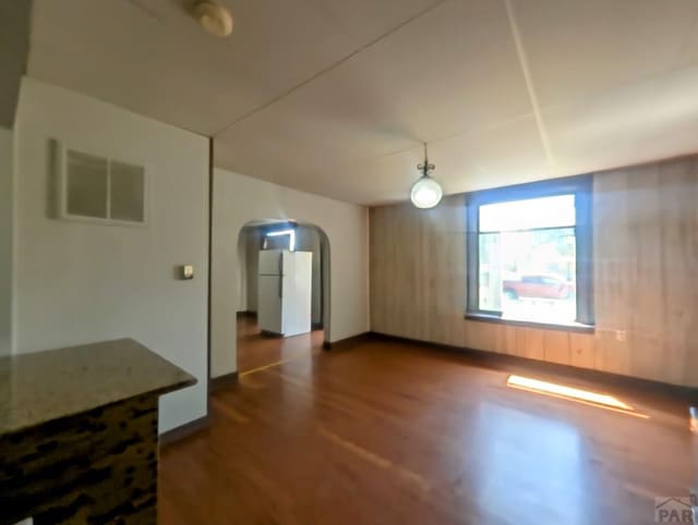 428 Elm Ave, Las Animas, CO 81054 - unfurnished living room with dark wood-type flooring and arched walkways