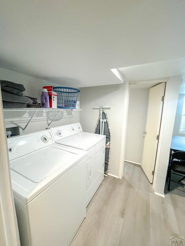 washroom with laundry area, light wood-style flooring, and washer and dryer