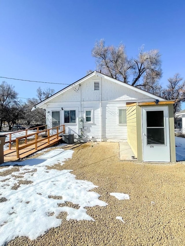 snow covered property featuring central air condition unit and a deck