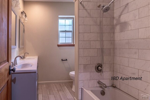 bathroom featuring double vanity, shower / bathing tub combination, a sink, and toilet